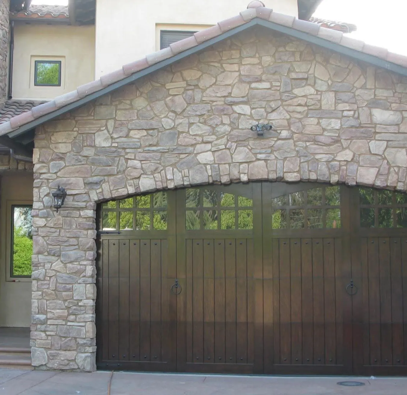 Stone home with an arched garage door